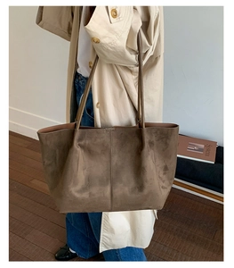 Macro detail of high-capacity dark brown suede tote bag with vertical stitching