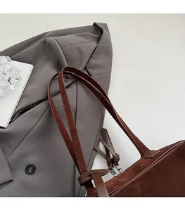 Close-up of comfortable double straps and matte brown suede texture on a French style bag