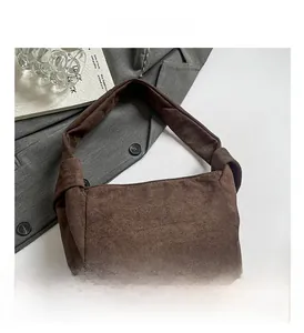 Vue détaillée d'un sac hobo en daim marron avec détail de nœud latéral au style vintage