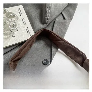 Détail de la bandoulière en daim marron confortable sur un sac cabas chic d'automne