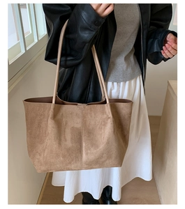 Detailed texture of brown matte suede tote bag with durable shoulder straps on model