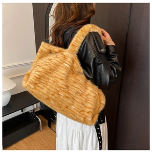 Dettaglio di una borsa a spalla grande in peluche leopardato abbinata a una gonna bianca