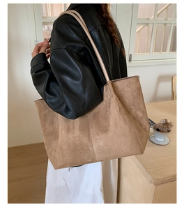 Brown faux suede tote bag shown on shoulder for large capacity and retro minimalist style