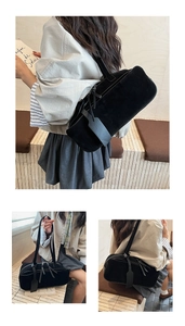 Detail of black matte suede shoulder bag featuring a decorative tag and long tassel zipper