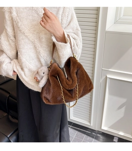 Sac à main en fausse fourrure marron avec chaîne dorée et petit lapin sur un pull blanc