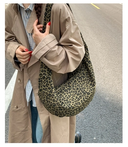 Detailed view of leopard print suede hobo bag on a model wearing a trench coat