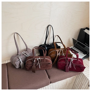 Group display of retro suede dumpling handbags in grey brown black tan and burgundy