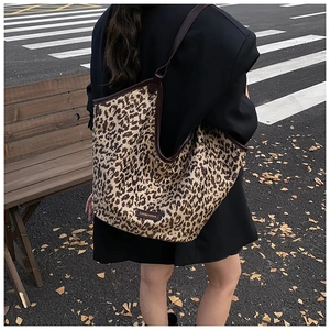 Détail du sac cabas léopard avec bordure en cuir marron dans un décor d'automne