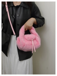 Detail van de roze handtas van imitatiebont met zachte textuur en lederen knoop