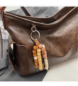 Detail of retro brown PU leather bucket bag with vintage crackle texture and wooden beads