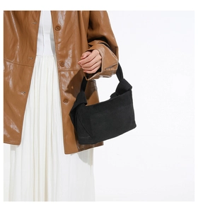 Détail du sac cabas en daim noir minimaliste avec poignée à nœud élégante