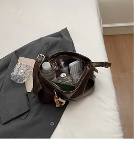 Spacious interior of dark brown dumpling bag showing storage for daily essentials