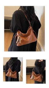 Detail view of caramel brown leather handbag with bohemian beaded tassel and adjustable strap