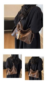 Detail of vintage brown shoulder bag with polished faux leather and wooden bead pendant