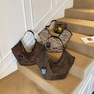 Sacs cabas hobo chics à imprimé léopard avec bandoulières noires sur un escalier