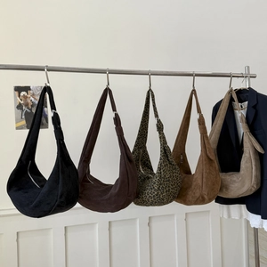 Dettaglio di borse tote in camoscio a forma di mezzaluna in vari colori su supporto
