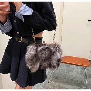Détail du sac seau pelucheux avec chaîne dorée et fermoir vintage porté par un mannequin
