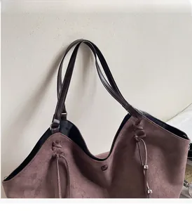 Detailansicht der dunkelbraunen Wildleder-Tragetasche mit Ledergriffen und Kordelzug-Details