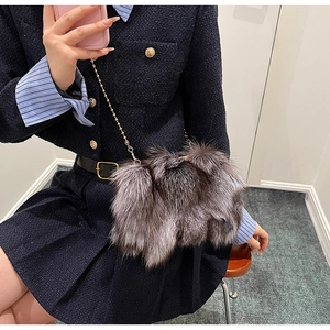 Détail du sac seau en peluche grise avec une fine bandoulière en chaîne dorée chic