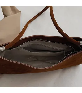 Détail de l'intérieur du sac en daim marron avec doublure à chevrons et zip