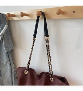 Détail du sac cabas en daim bordeaux avec poignées en chaîne dorée et cuir noir