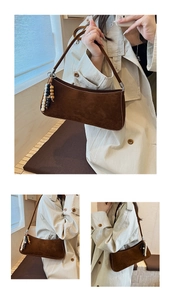 Détail du sac baguette en daim marron avec gland en perles de bois et texture rétro