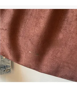 Gros plan d'un sac seau en daim fauve avec marquage doré et texture mate douce