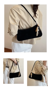 Détail du sac baguette en daim noir avec breloque en perles de bois colorées et style rétro chic