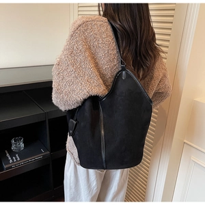 Detail of large black vintage tote bag with wavy edge on model in minimalist interior
