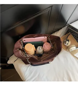 Vue intérieure d'un sac seau en daim marron avec bandoulière et grand rangement