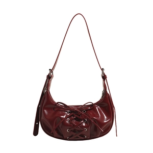 Dark red patent leather crescent bag with lace-up detail and silver metal eyelets