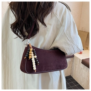 Detail of dark burgundy suede hobo bag with vintage wooden beads and silver hardware