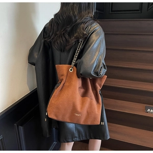 Détail de sac porté épaule en suédine marron, idéal pour l'automne et l'hiver au quotidien.