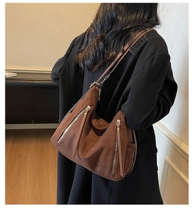 Hobo shoulder bag in dark brown suede finish with decorative tassels on a model