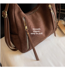 Detail of vintage brown suede tote with dual gold zippers and long leather pullers