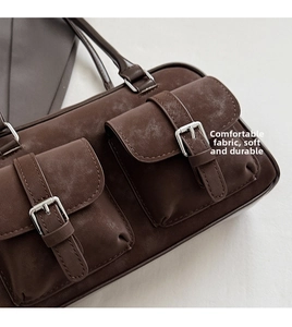 Close-up of retro brown Boston bag with dual pockets and silver metal buckle details