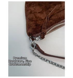Close-up of premium metal hardware, durable zipper and chain on dark brown suede bag