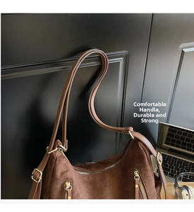 Detail of brown suede tote with gold hardware and dual vertical zippers for commute