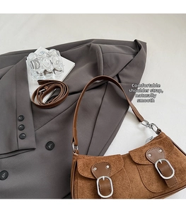 Détail du sac hobo vintage en daim marron avec poches doubles et bandoulière réglable