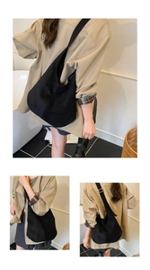 Detail of matte black hobo bag showing adjustable strap and golden hardware accents