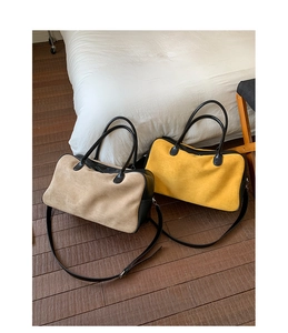 Detail of matte suede tote bags in beige and yellow patchwork on wooden floor