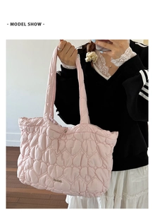 Close-up of pink heart quilted tote bag showing padded texture and slim shoulder straps