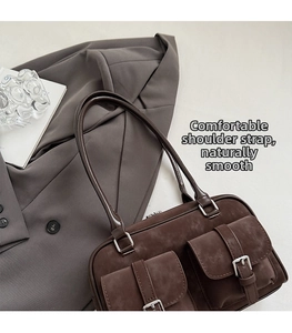 Detail of vintage coffee frosted Boston bag with dual front pockets on grey blazer