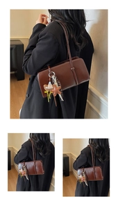 Détail du sac sous le bras en cuir marron vintage avec pendentifs étoile et écharpe