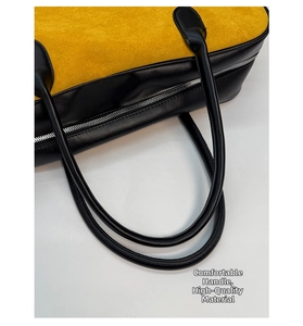 Close-up of color-block canvas handbag with silver metal zipper and black handles
