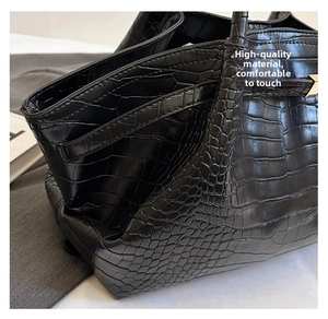 Close-up of black crocodile embossed faux leather texture on the side of the handbag