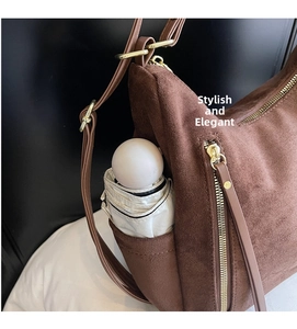Detail of brown faux suede shoulder bag side pocket showing umbrella storage functionality