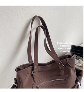 Détail du grand sac cabas marron foncé avec attaches anneaux en métal et zip frontal