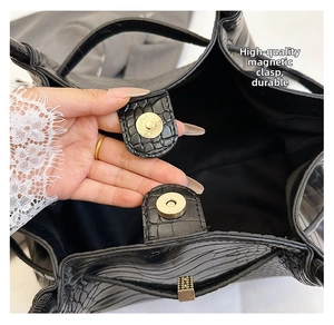 Detail of black stone pattern leather bag featuring a secure gold magnetic snap closure