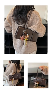Détail du sac baguette vintage avec breloque ours et étoile en cuir sur la bandoulière